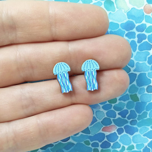 Wooden blue jellyfish stud earrings held on hand