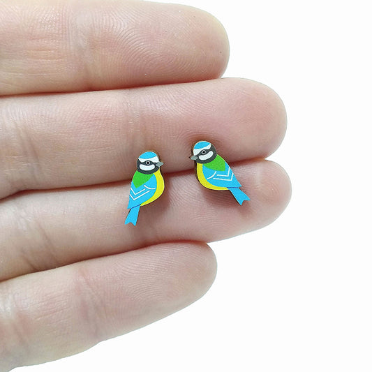 Wooden blue tit stud earrings held on hand, in yellow, blue, green and black