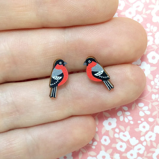 Wooden bullfinch stud earrings held on hand
