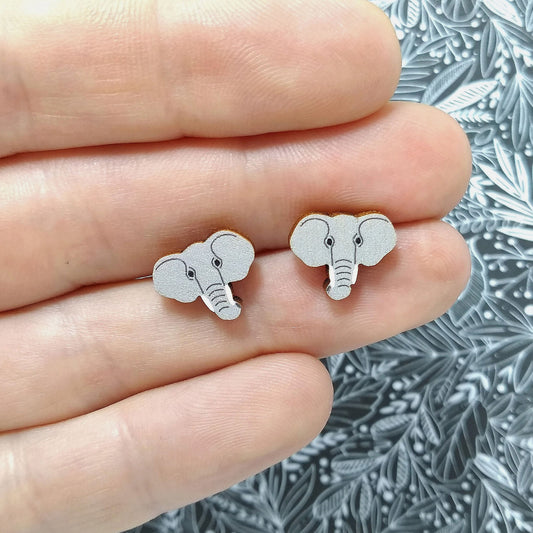 Wooden elephant stud earrings held on hand
