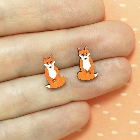 Wooden fox stud earrings held on hand