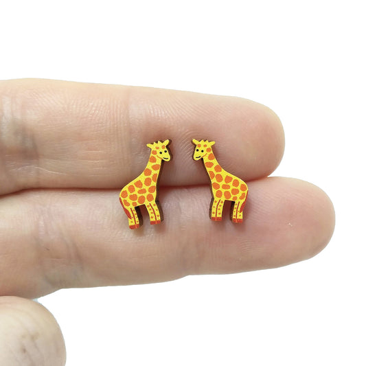 Wooden giraffe stud earrings held on hand