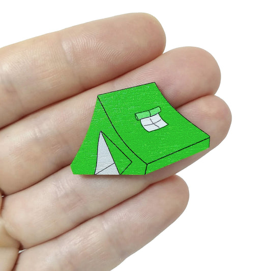 Wooden green tent pin badge held on hand