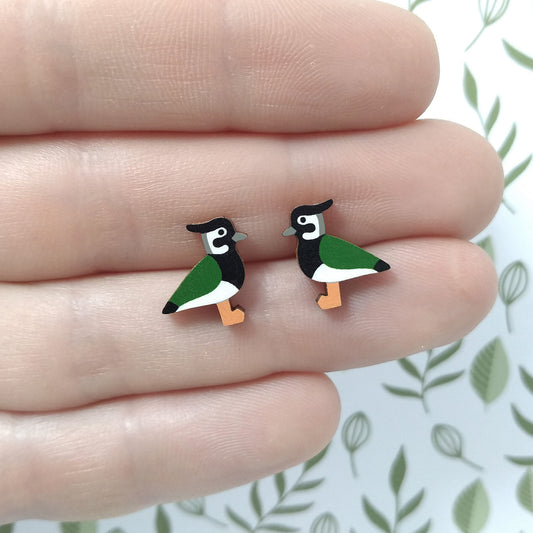 Wooden lapwing stud earrings held on hand