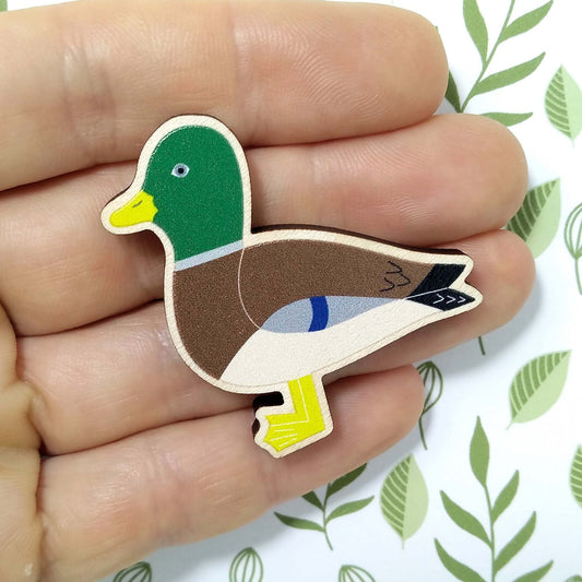 Wooden mallard pin badge held on hand