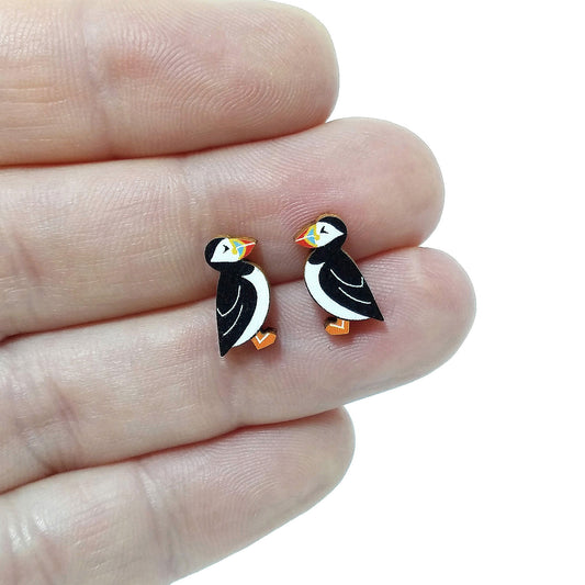 Wooden puffin stud earrings held on hand