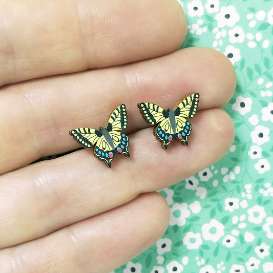 Wooden swallowtail butterfly stud earrings held on hand
