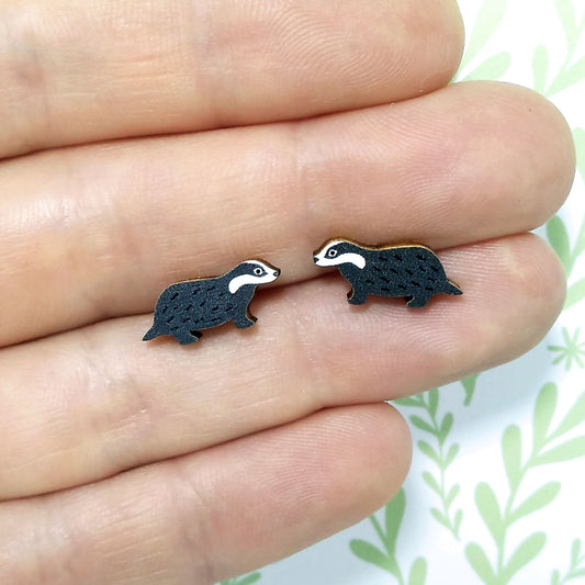 Wooden badger stud earrings held on hand
