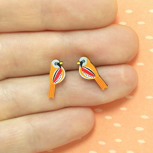 Wooden bearded tit stud earrings held on hand