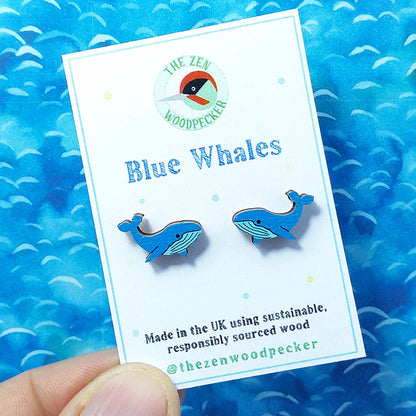 Wooden blue whale stud earrings on display card