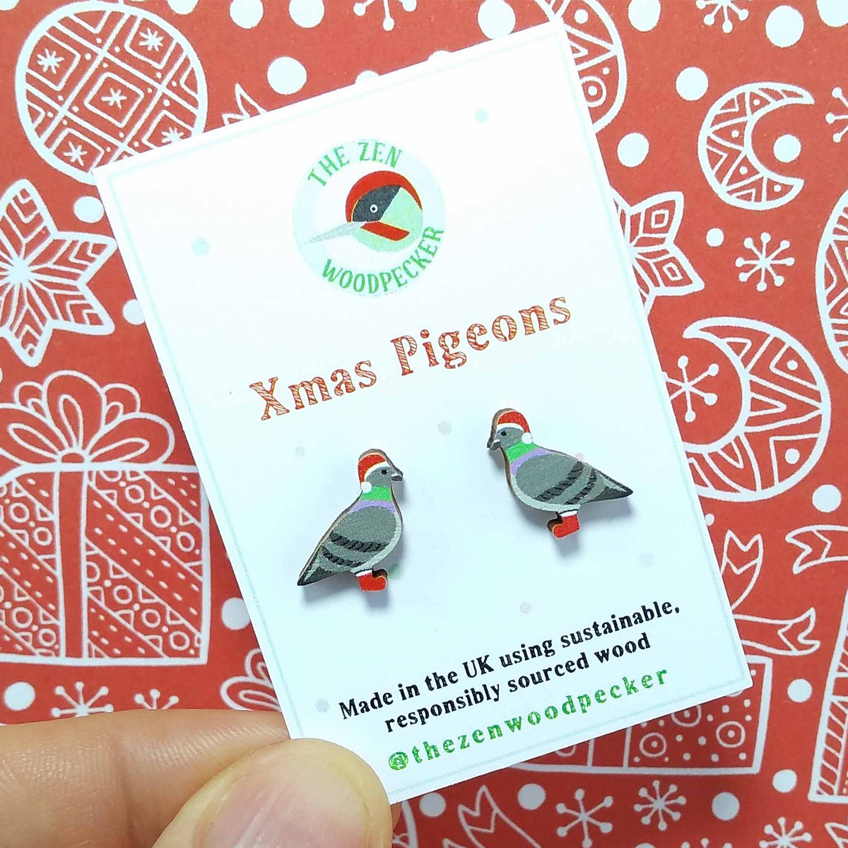 Christmas pigeon stud earrings on display card, made of wood, the pigeons are wearing red santa hats and red boots