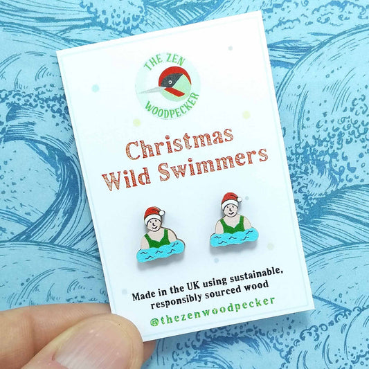 Christmas wild swimmer stud earrings on display card, made of wood, the swimmers are wearing red santa hats