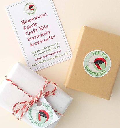 Eco friendly card gift box with logo sticker, another box gift wrapped in tissue paper and tied with string, and a business card