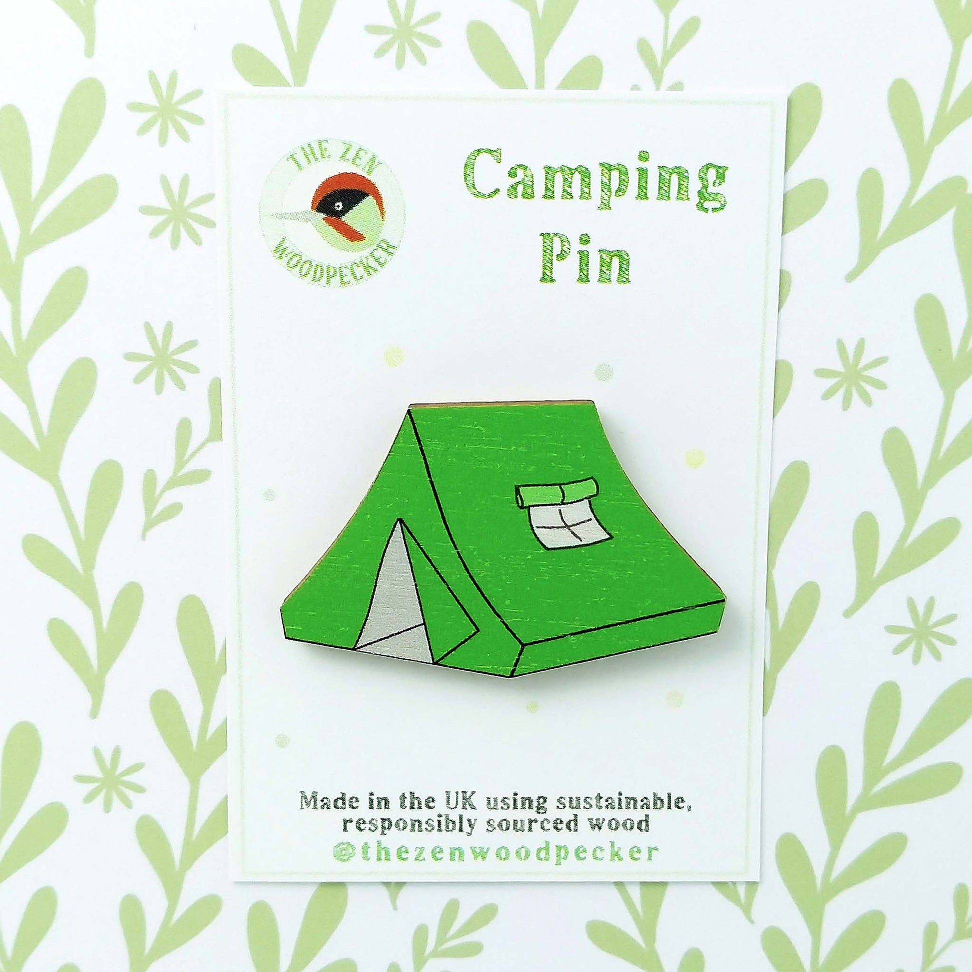 Wooden green tent pin badge on display card