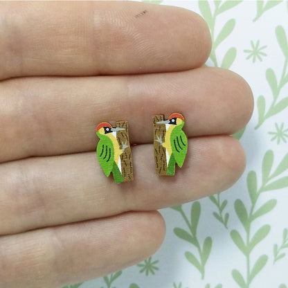 Wooden green woodpecker stud earrings held on hand