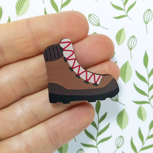 Wooden hiking boot pin badge held on hand