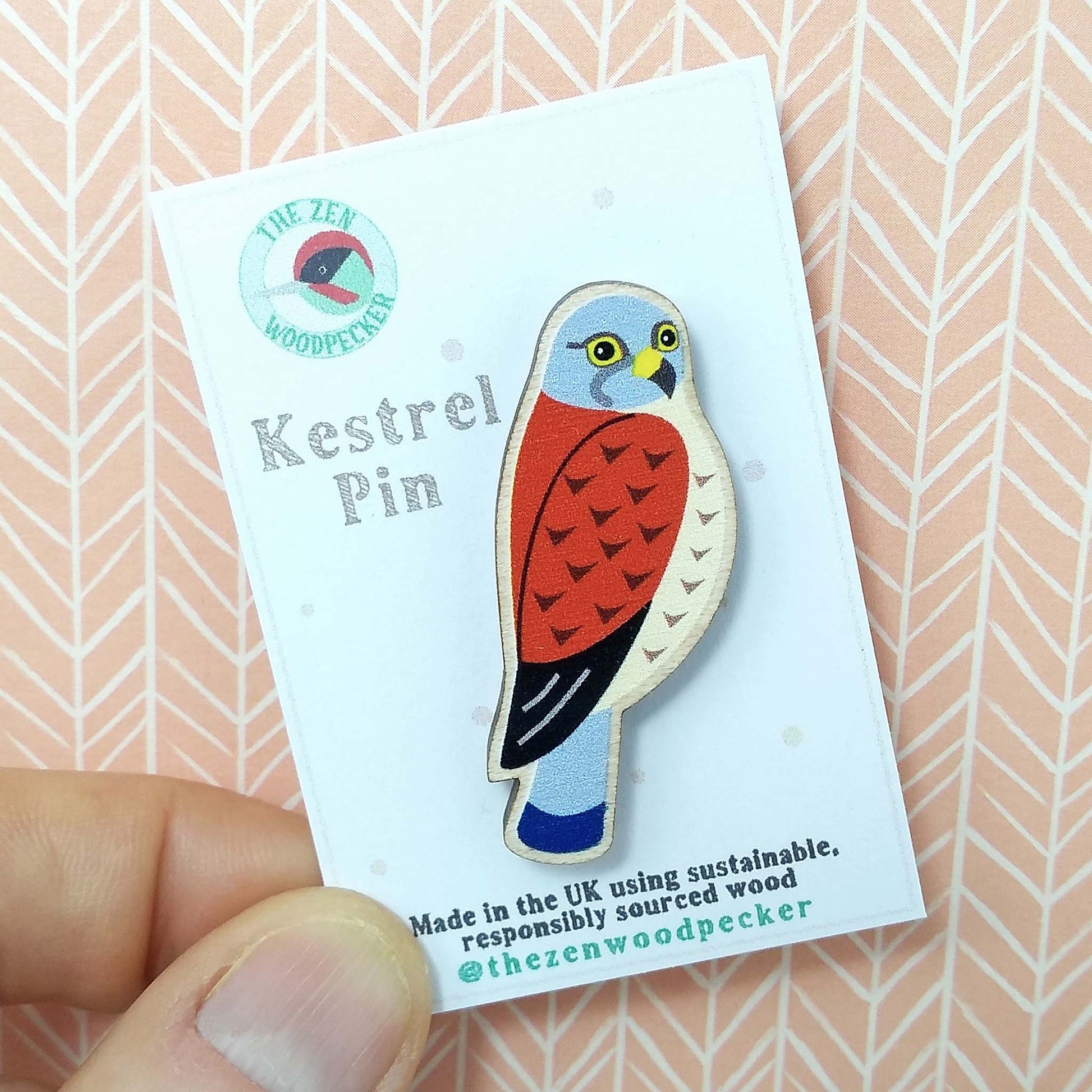 Wooden kestrel pin badge on display card