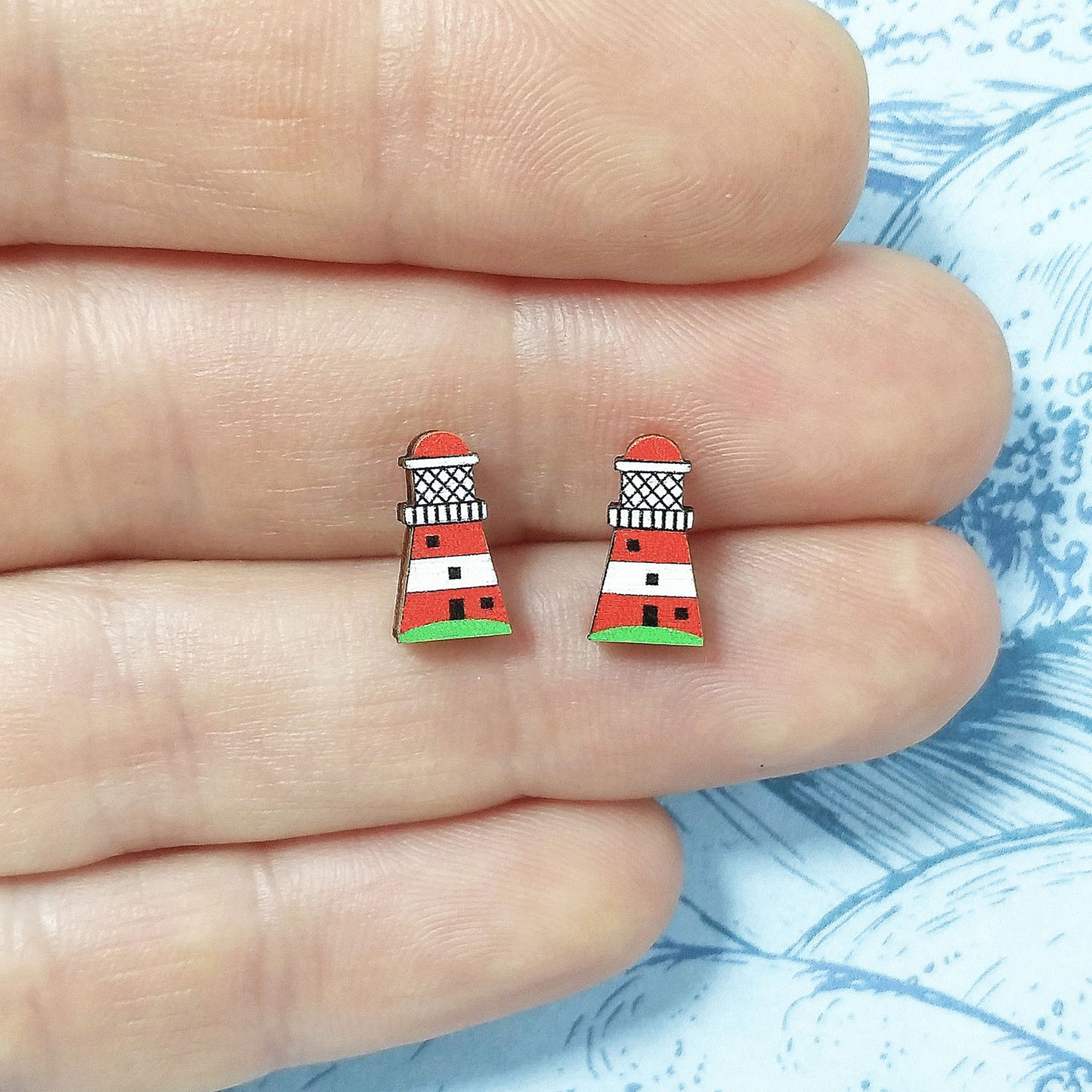Wooden lighthouse stud earrings held on hand