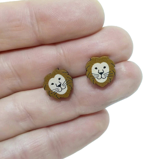 Wooden lion stud earrings held on hand