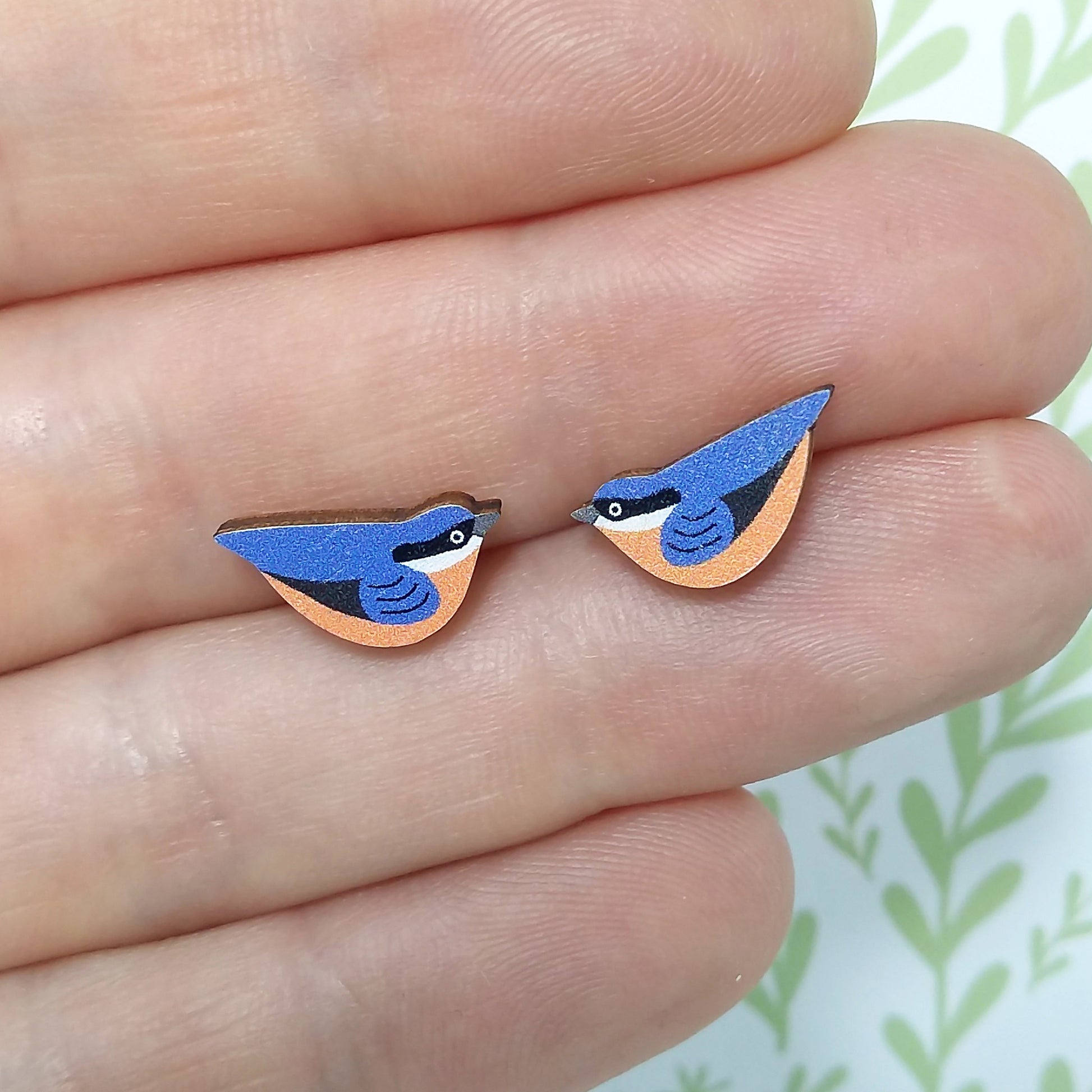Wooden nuthatch stud earrings held on hand