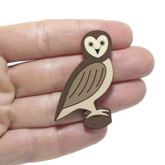 Wooden owl pin badge held on hand