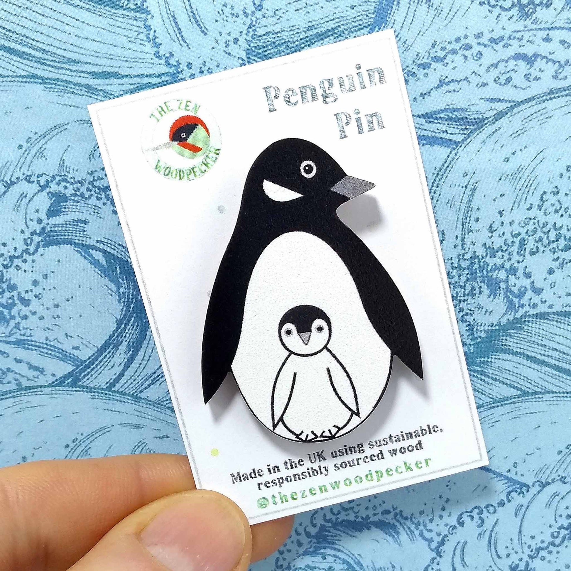 Wooden penguin pin badge on display card
