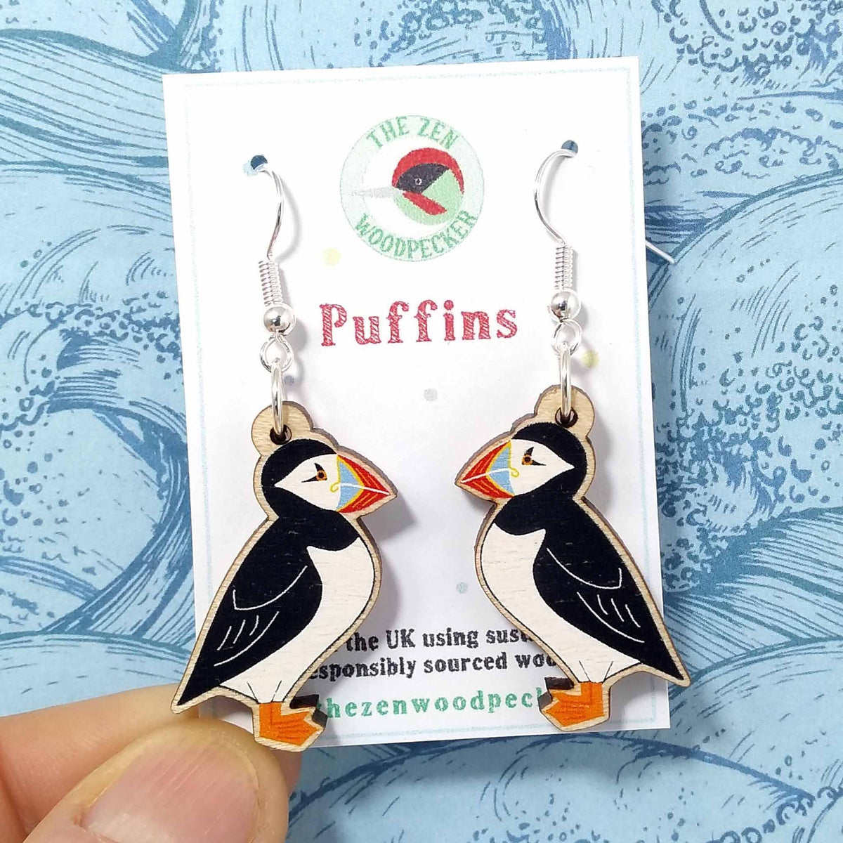 Wooden dangly puffin earrings on display card