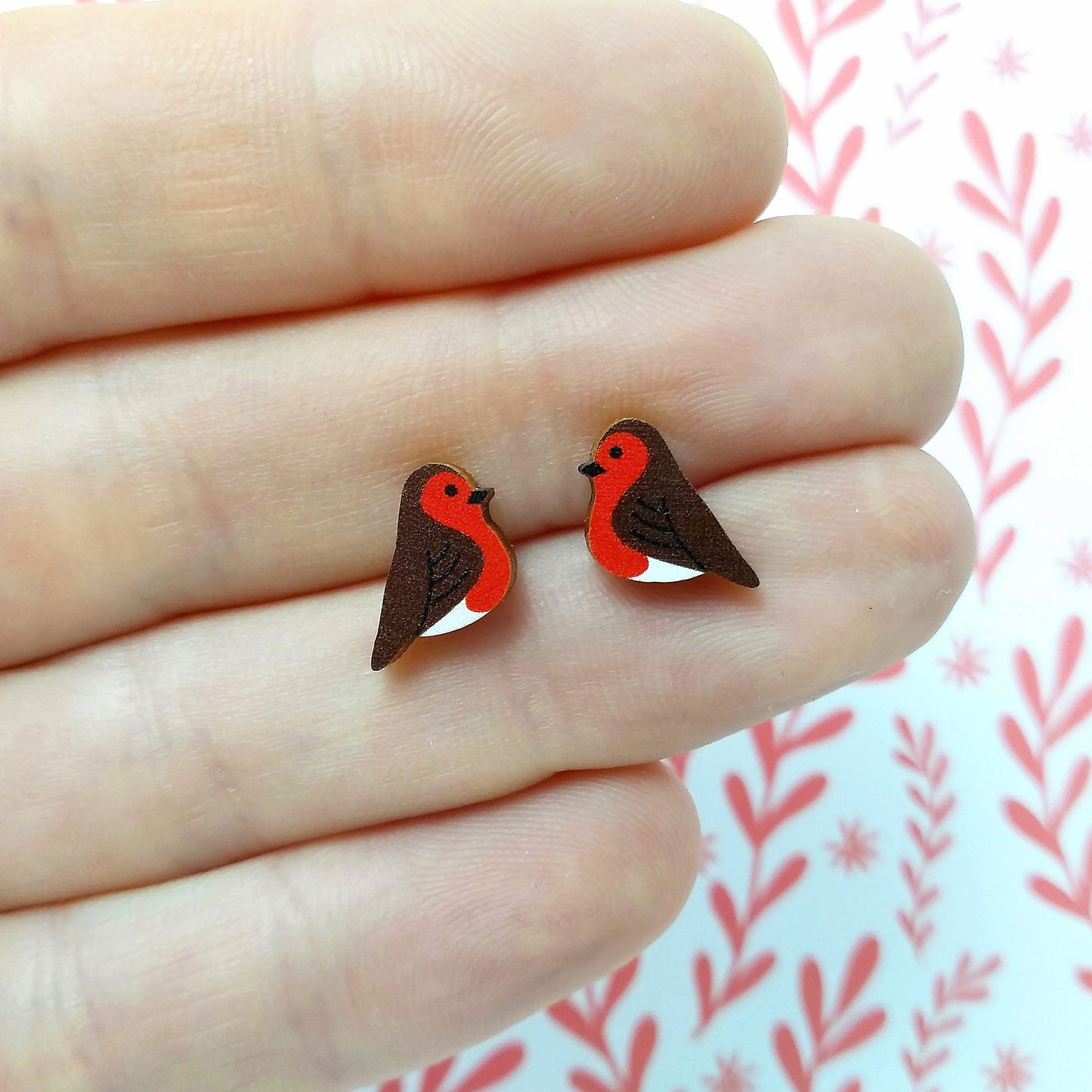 Wooden robin stud earrings held on hand