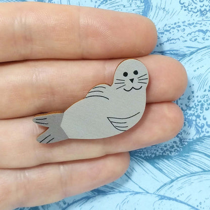 Wooden seal pin badge held on hand