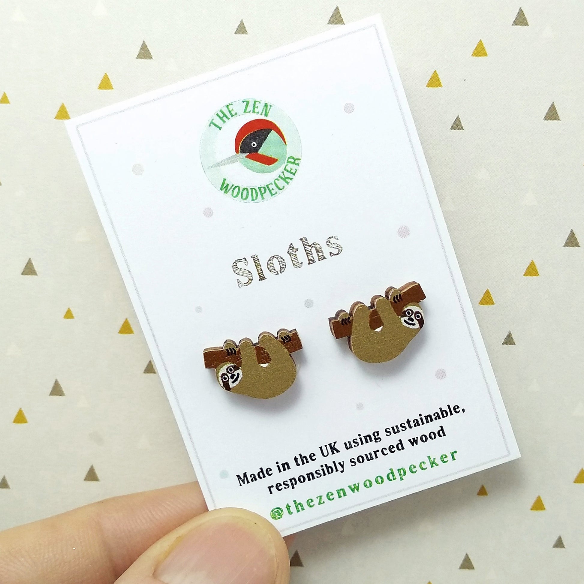 Wooden sloth stud earrings on display card