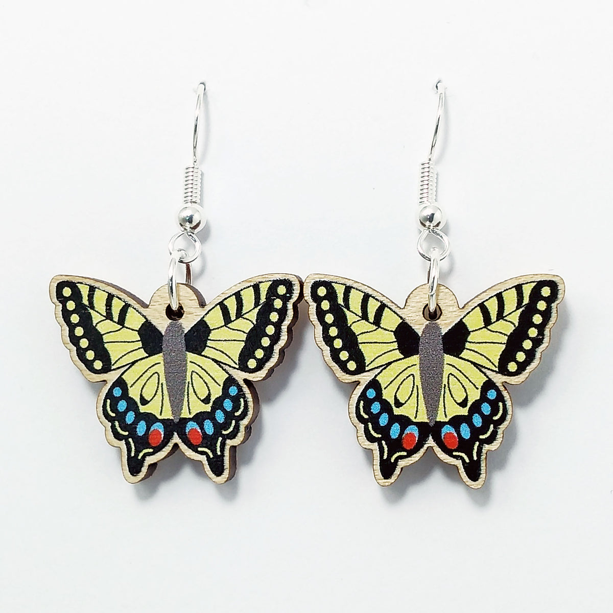Wooden swallowtail dangle earrings on white background 