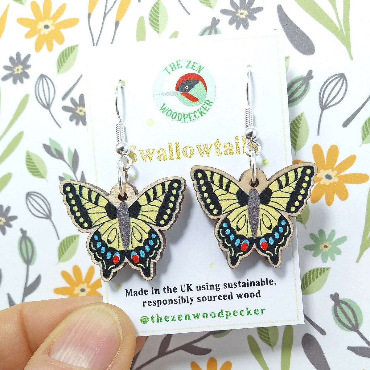 Wooden dangly swallowtail earrings on display card