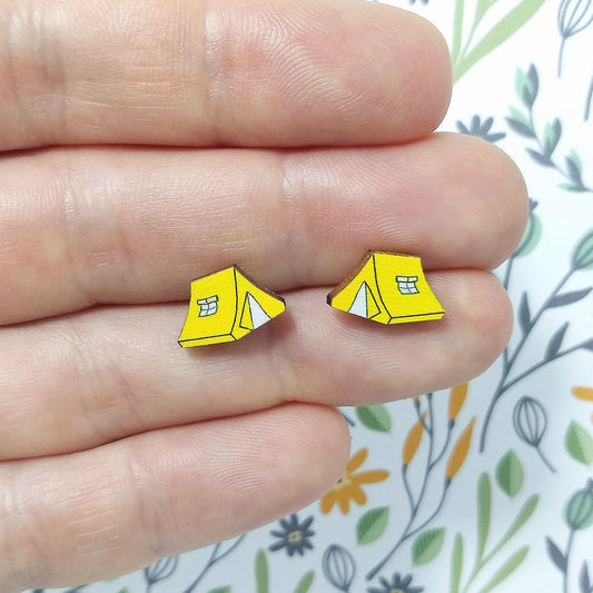Wooden yellow tent stud earrings held on hand