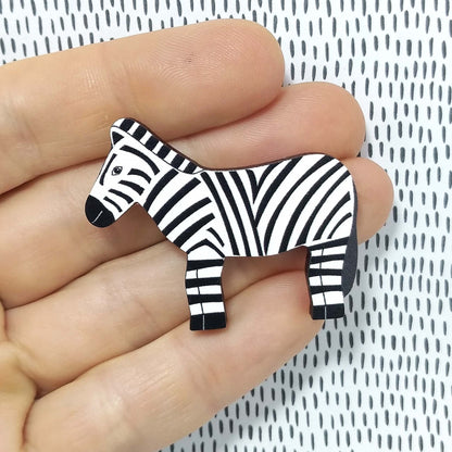 Wooden zebra pin badge held on hand