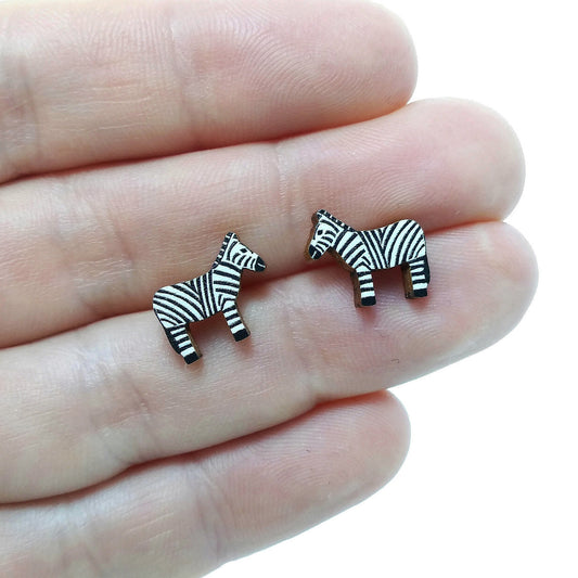 Wooden zebra stud earrings held on hand